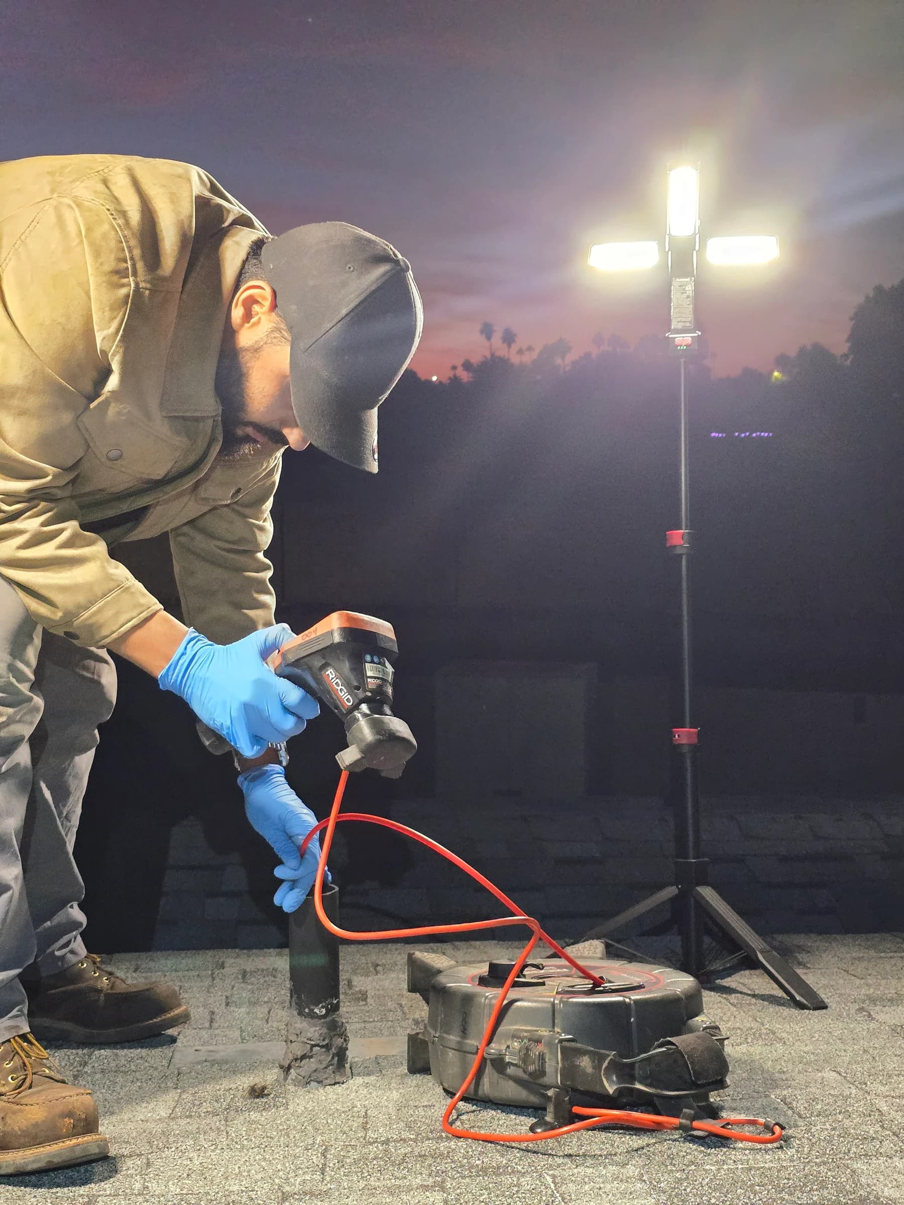Locating a sewer problem at night, work lights up.