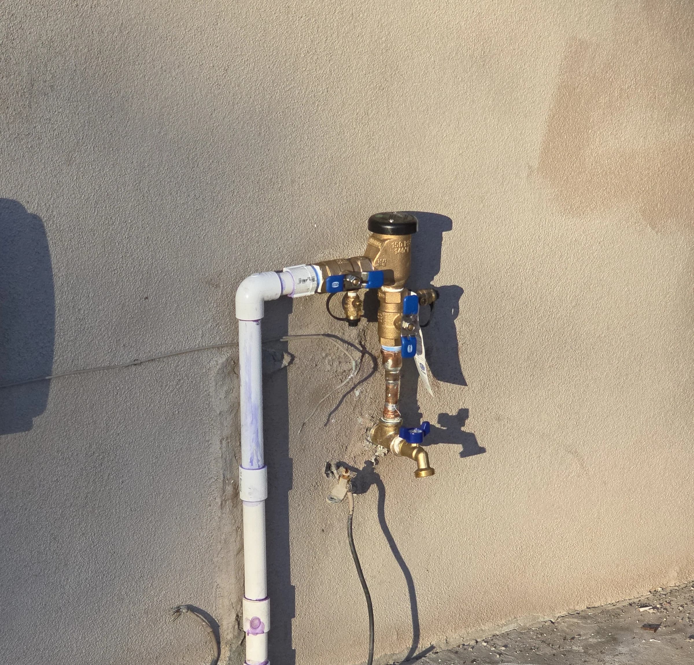 New hose bibb and vacuum breaker, sealed against the stucco.