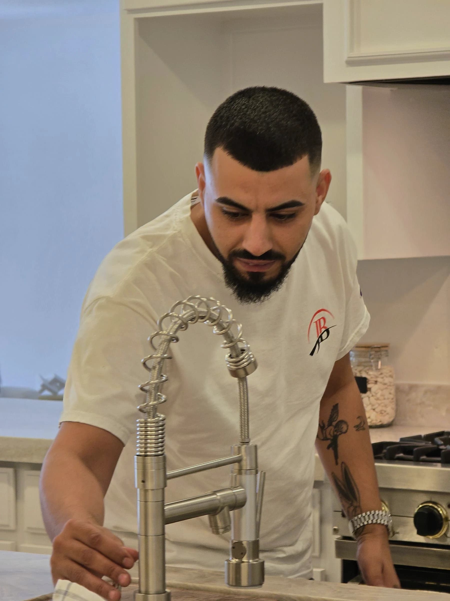 Judai Brothers technician working on a kitchen faucet in a client's home