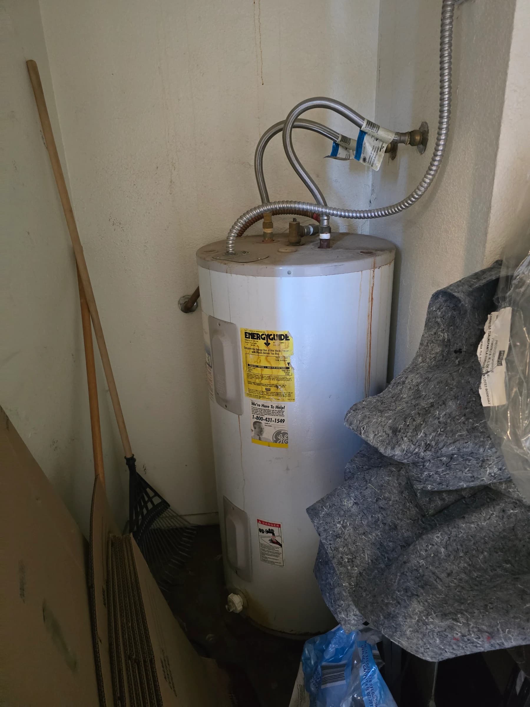 Before: Rusted-through electric tank, replaced with a new Rheem in the same corner. Same day.