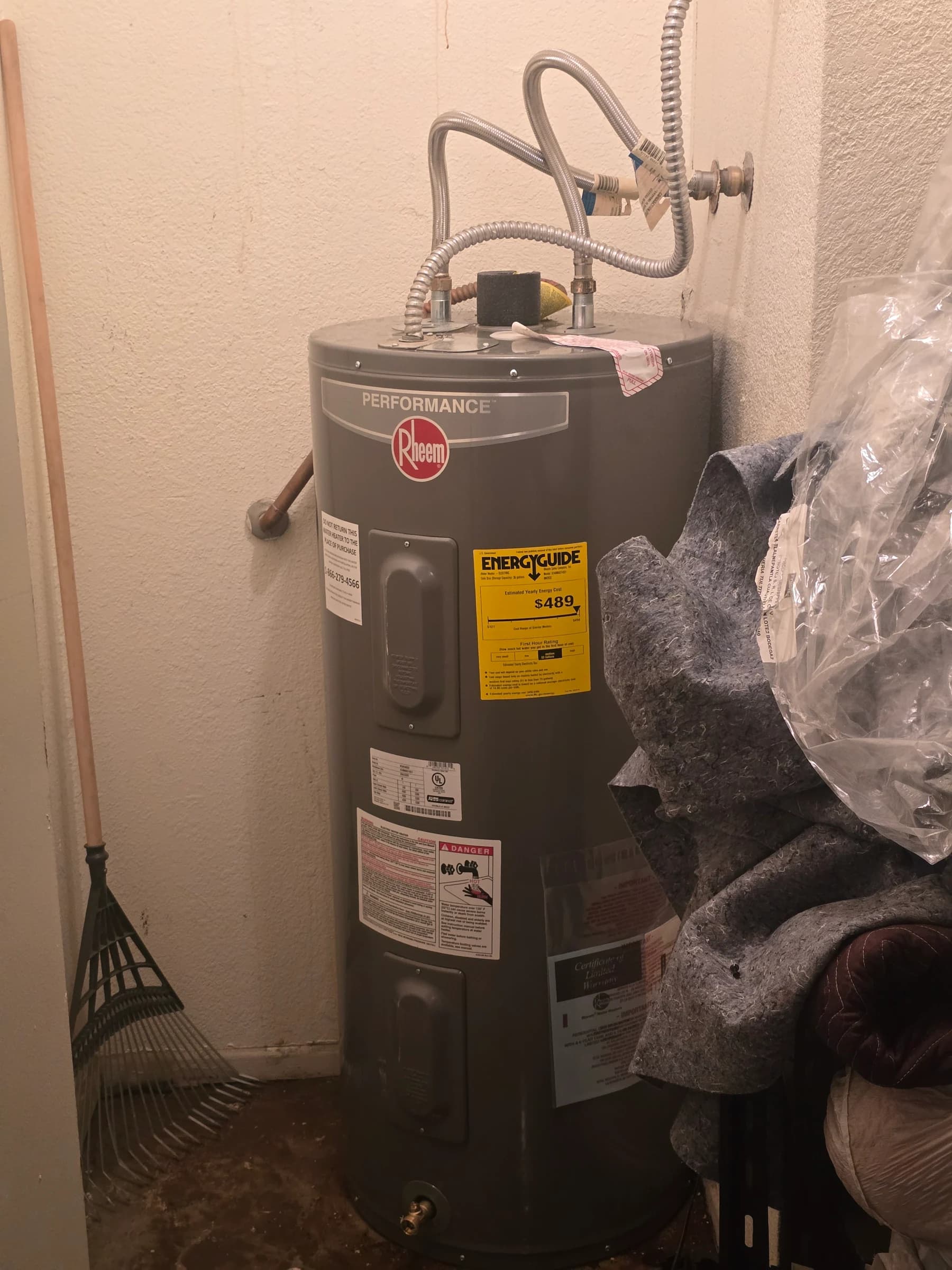 After: Rusted-through electric tank, replaced with a new Rheem in the same corner. Same day.